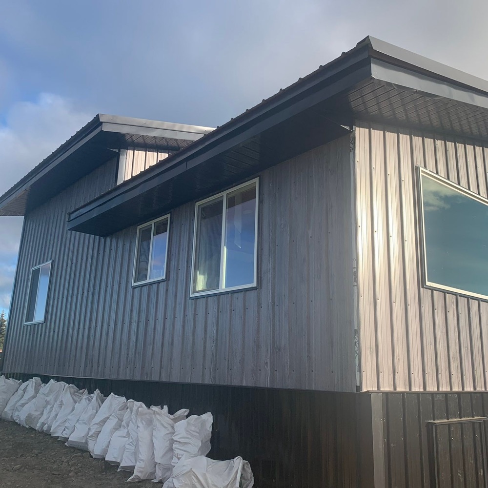Board siding, metal wainscot and a metal roof with matching fascia