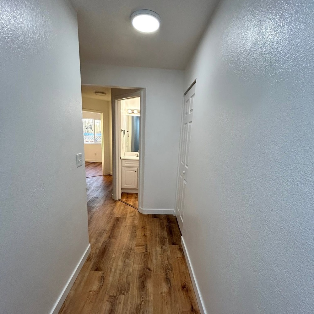 Hallway after paint and trim, plank floor running through